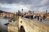 Thumbnail image of tourists walk on the Charles Bridge under a stormy sky, Prague, Czech Republic